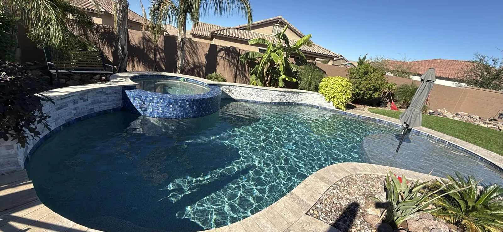 Raised spa with blue glass tile and spillway, clean stonework, San Tan Valley Arizona pool