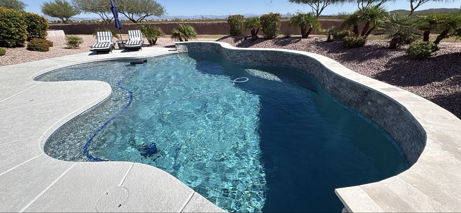 Raised stacked-stone wall and scupper during weekly cleaning, San Tan Valley Arizona