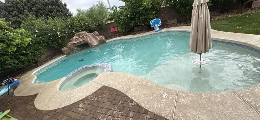Light haze on pool water in a Queen Creek, Arizona freeform pool with pebble finish