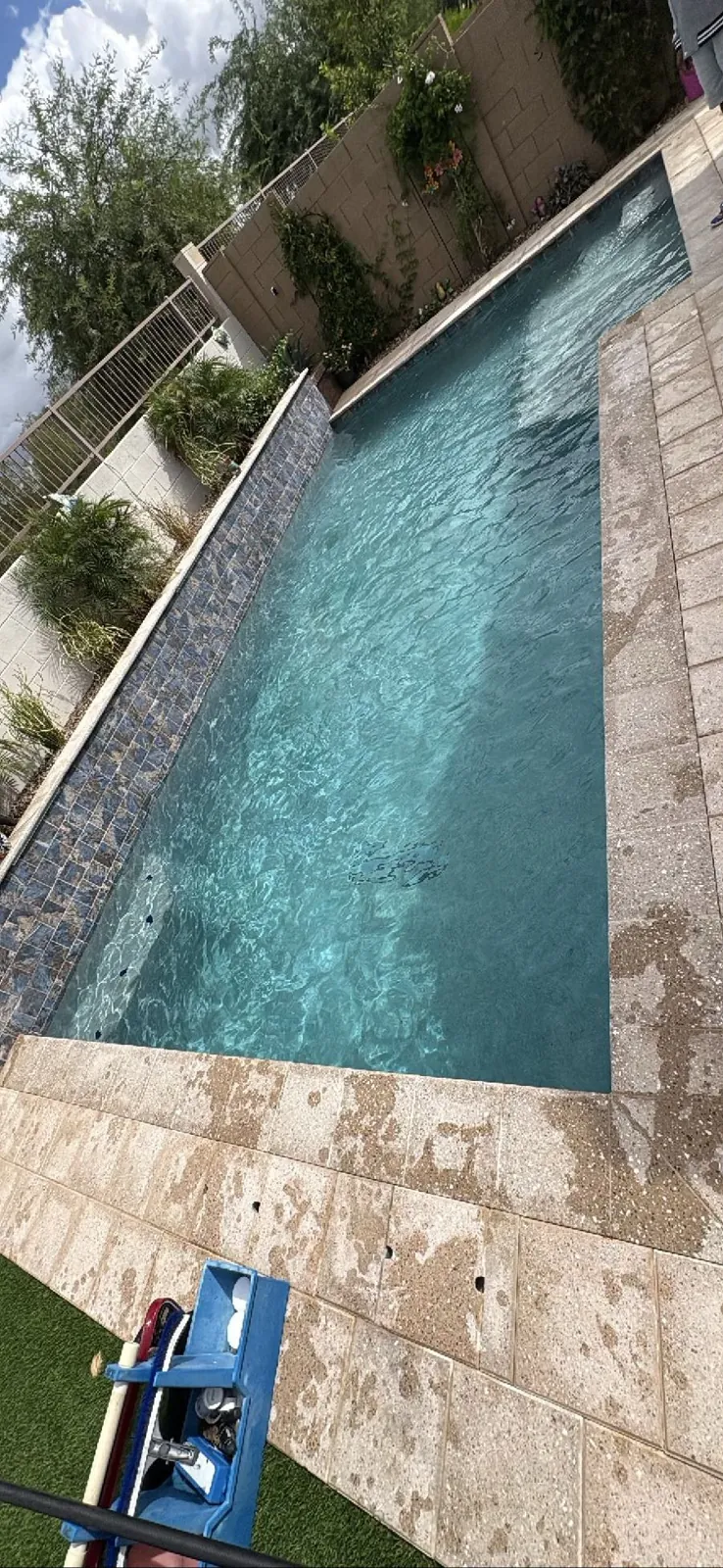 Mosaic tile raised wall feature with mineral spotting on deck in a Queen Creek, Arizona pool