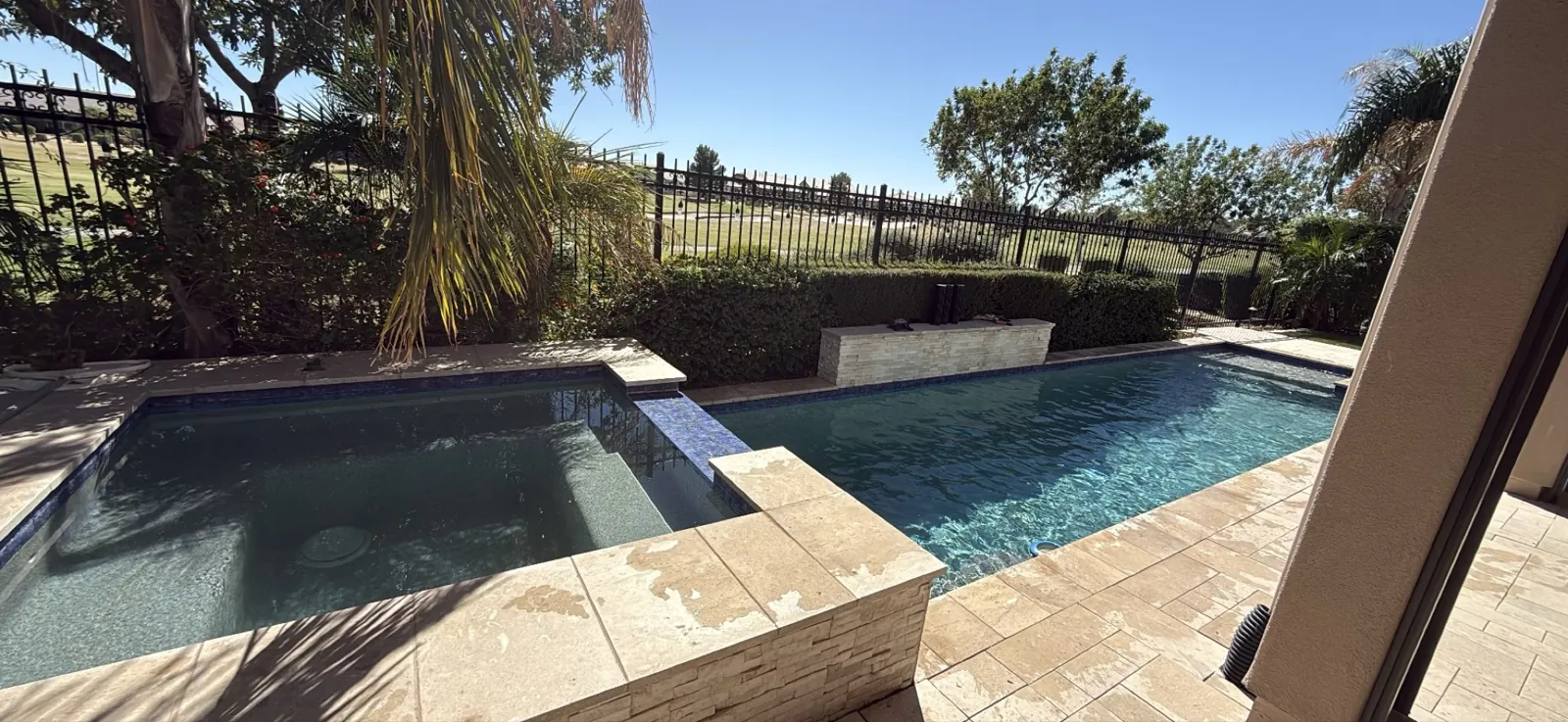 San Tan Valley pool with raised spa showing slightly cloudy water and minor tile staining