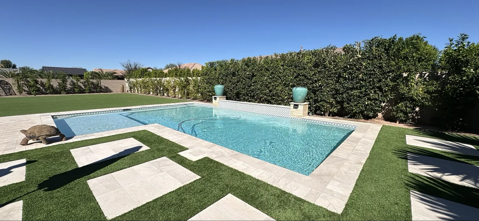Clear Queen Creek pool with travertine decking during Pentair air relief valve check