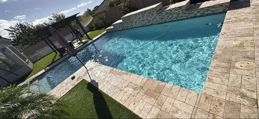 Queen Creek pool weekly service stop with skimmer pole in clear water near tile wall