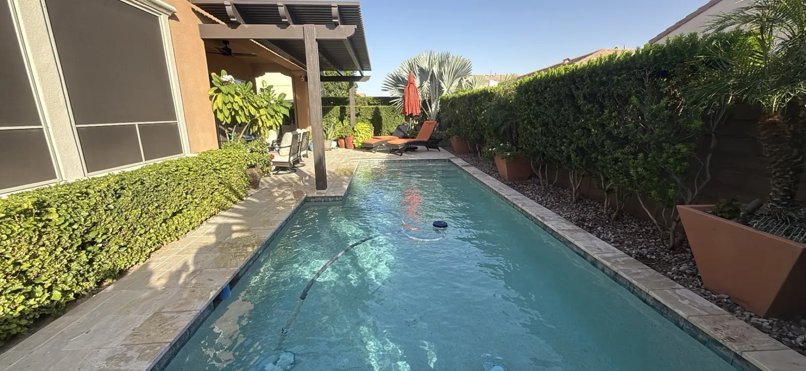 Clean travertine deck and clear lap pool during weekly service in Queen Creek