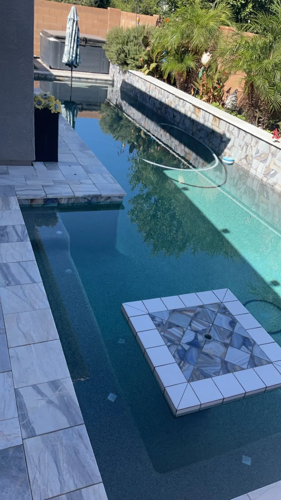 Dark-bottom Queen Creek pool with stacked stone wall during evaluation visit